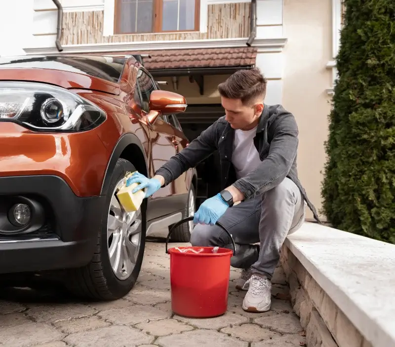 Lavage auto à domicile Curvalle : professionnel intervenant sur un véhicule